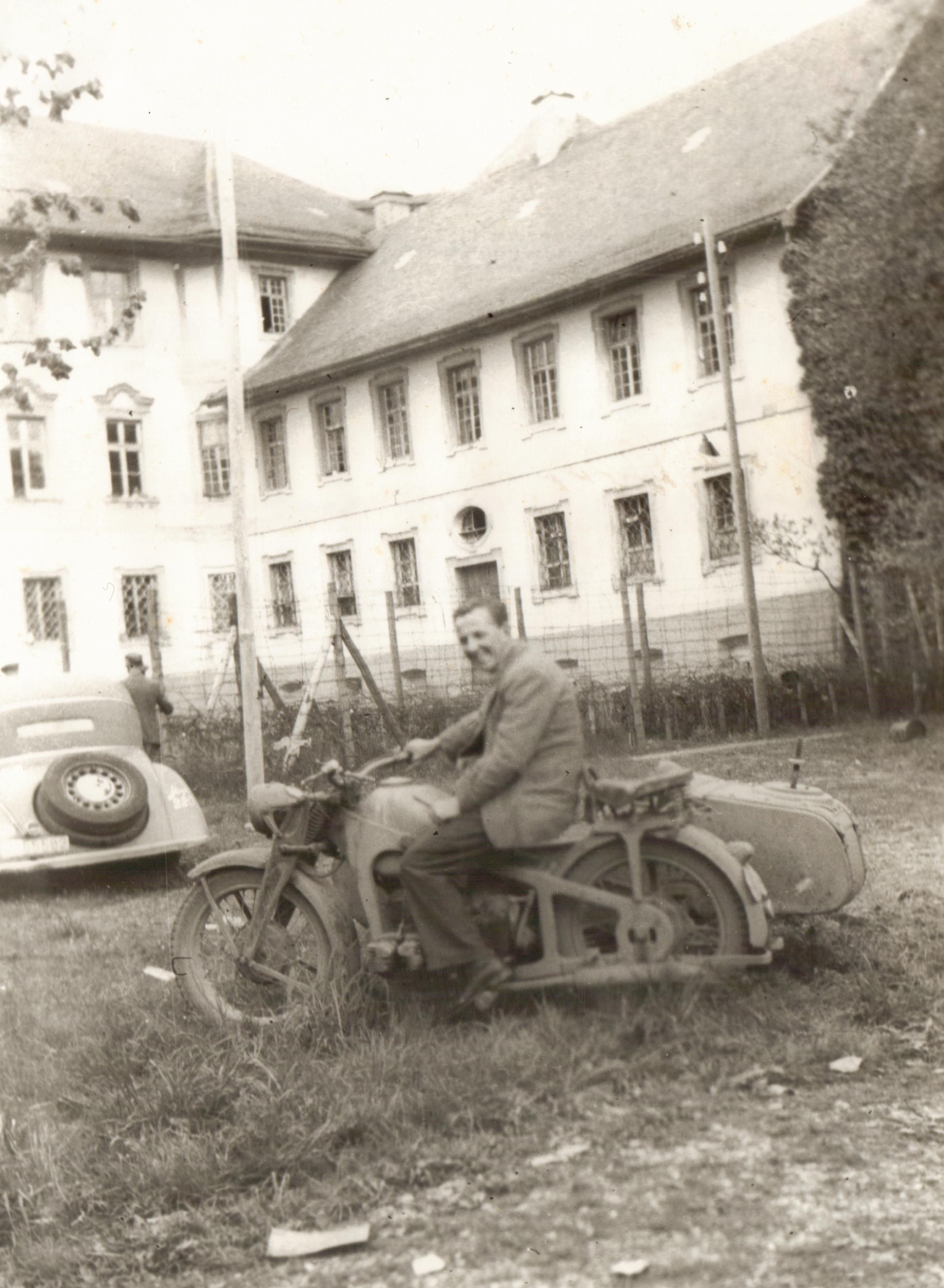 Harold 'Happy' Hepburn sitting on a German motorcycle just after the Liberation of Bad Wuzach, April 1945.