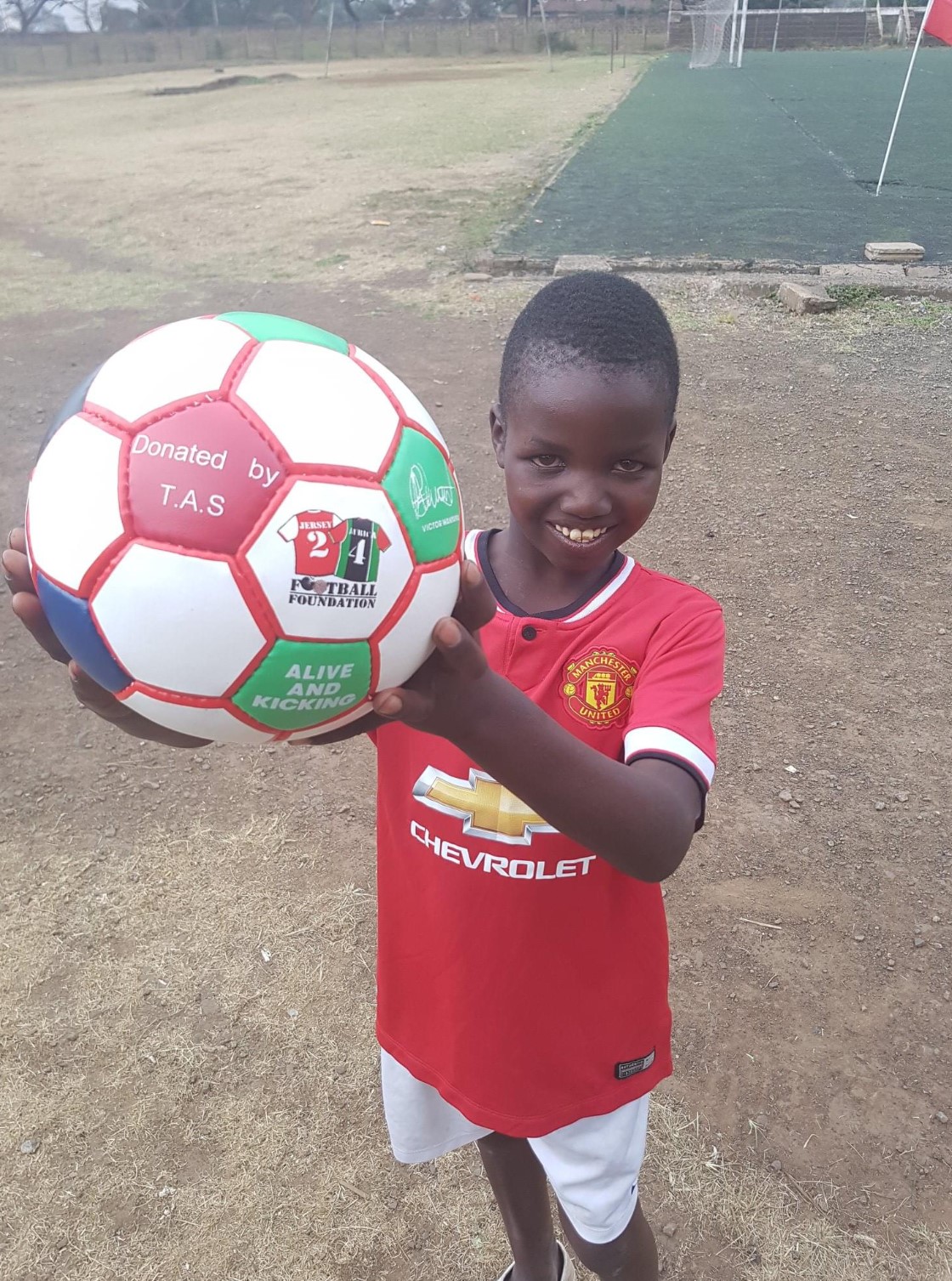 Football_held_proudly_by_Kenyan_child.jpg