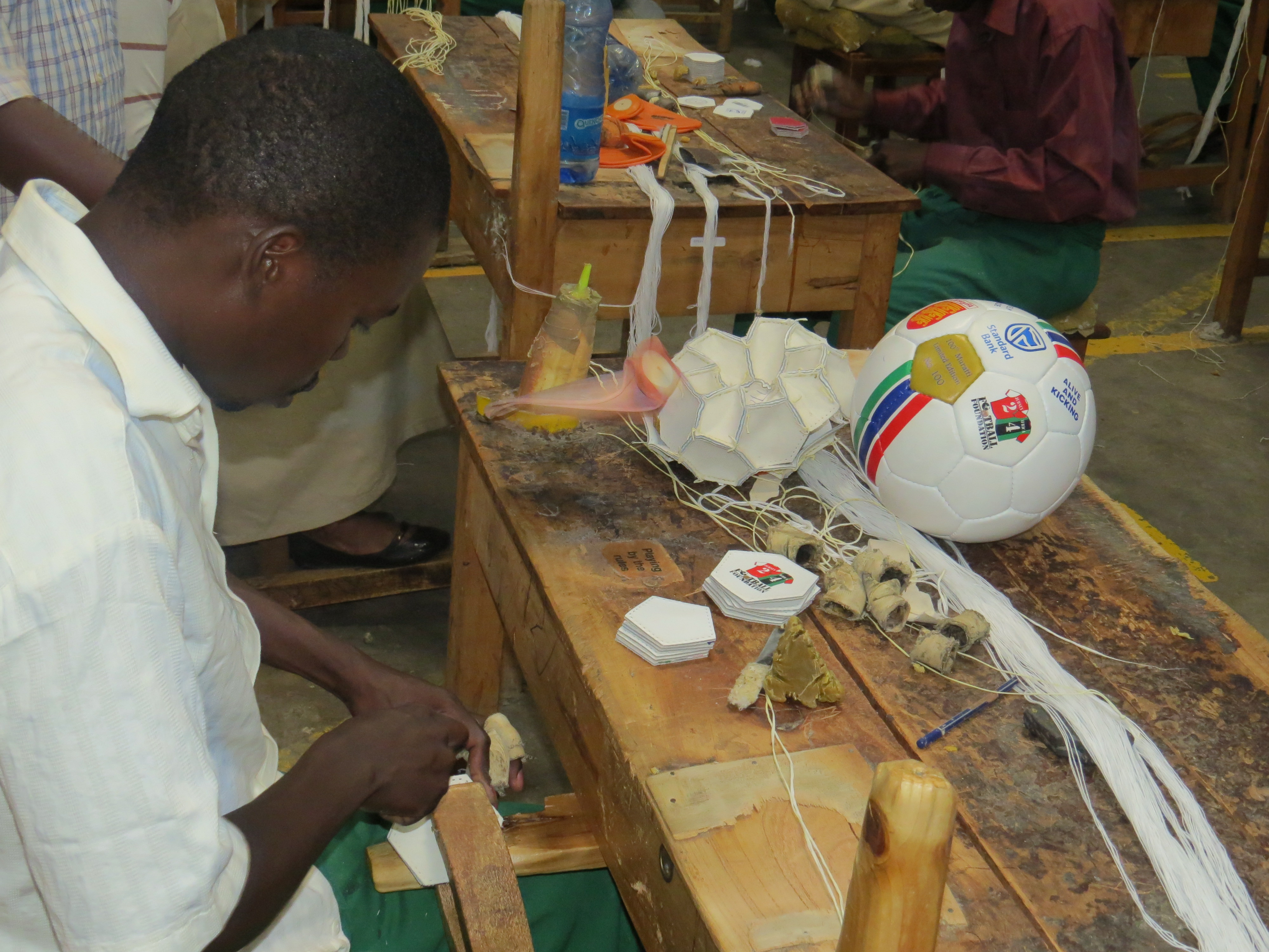 Worker_at_AK_factory_in_Nairobi_hand_stitching_a_football.jpg