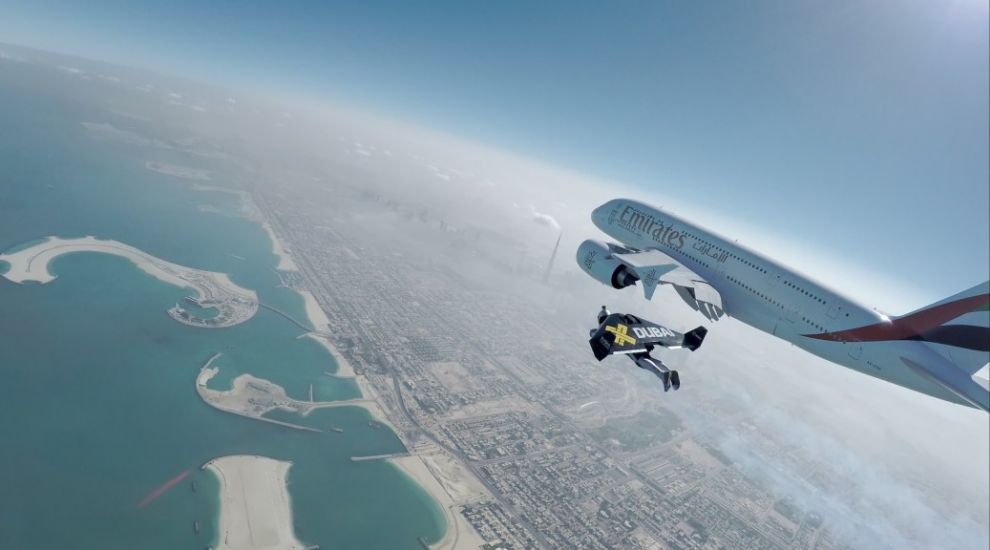 Watch two men with just a wing strapped to their bodies fly alongside the world's largest passenger plane