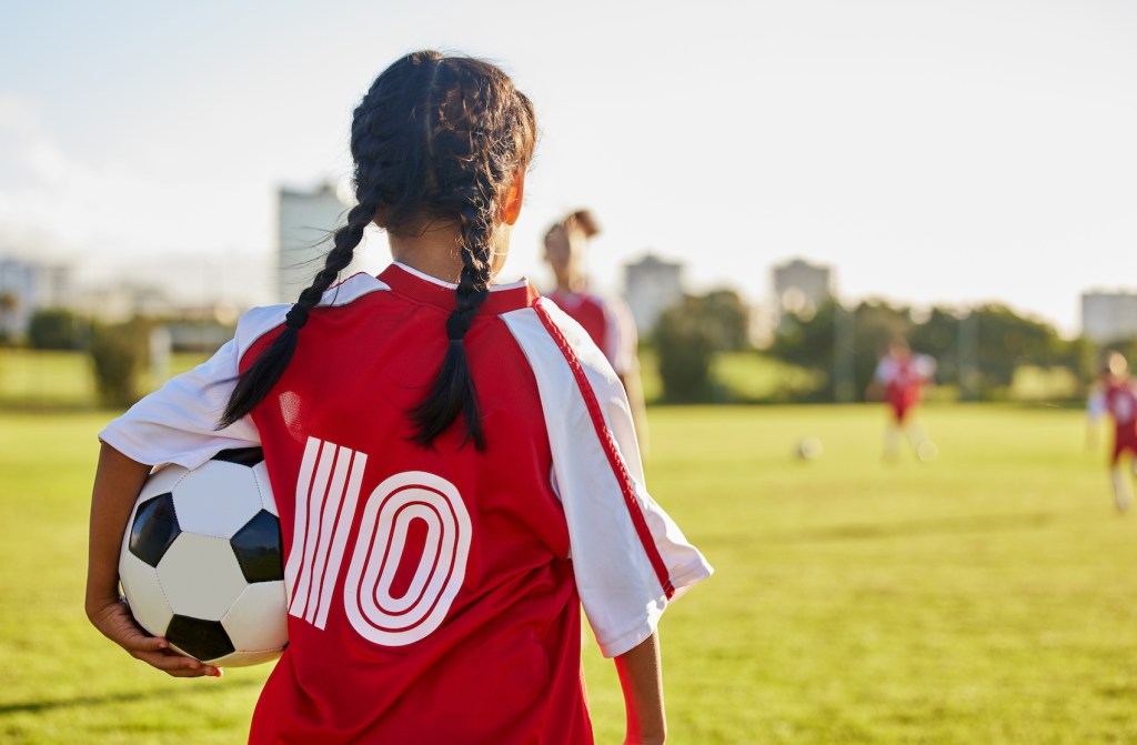 girl holds football