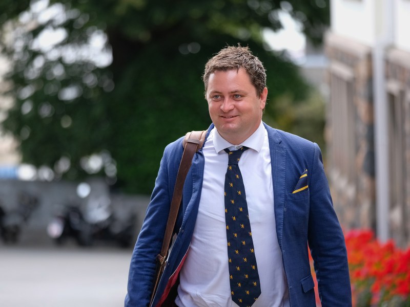 A man in a suit asks down a road.