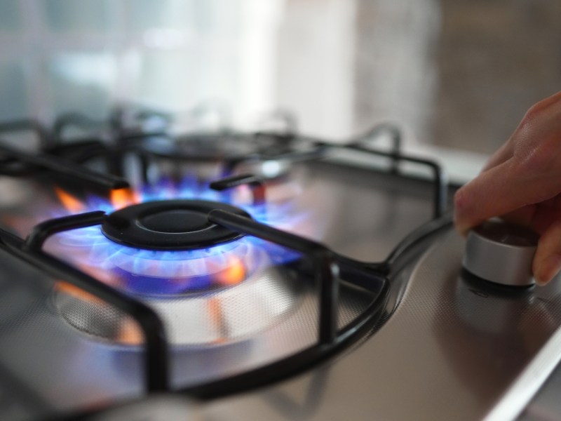 Person turning on the gas burner on a stove