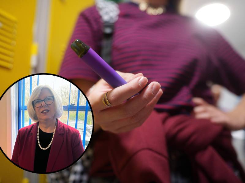 A young girl in a purple t-shirt vapes. She's standing in front of yellow school lockers, with a bag over her shoulder and a sweater tied around her waist. An inset of a professional woman with grey hair in a burgundy jacket.