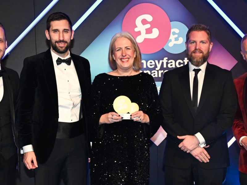 Three businessmen and one woman collect an award from celebrity judge and author Rob Rinder.