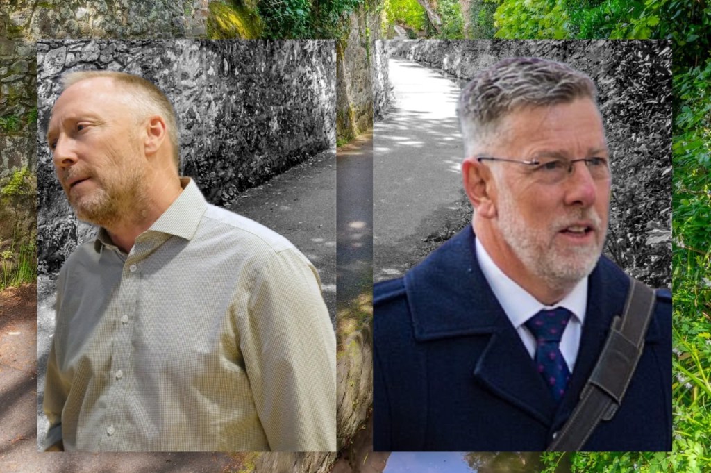 Two separate portrait-style photographs are placed side by side against an outdoor background of a narrow, tree-lined lane bordered by old stone walls.
On the left, an individual is wearing a light-coloured, long‑sleeved button-up shirt and is positioned at a slight angle, standing in front of a rough stone wall.
On the right, another individual is wearing a dark overcoat, a collared shirt and patterned tie, along with a shoulder strap from a bag. Both individuals are shown from the shoulders up.
The background behind each portrait shows the same lane from different angles: a paved path bordered by a mossy stone wall on one side and dense greenery on the other.
