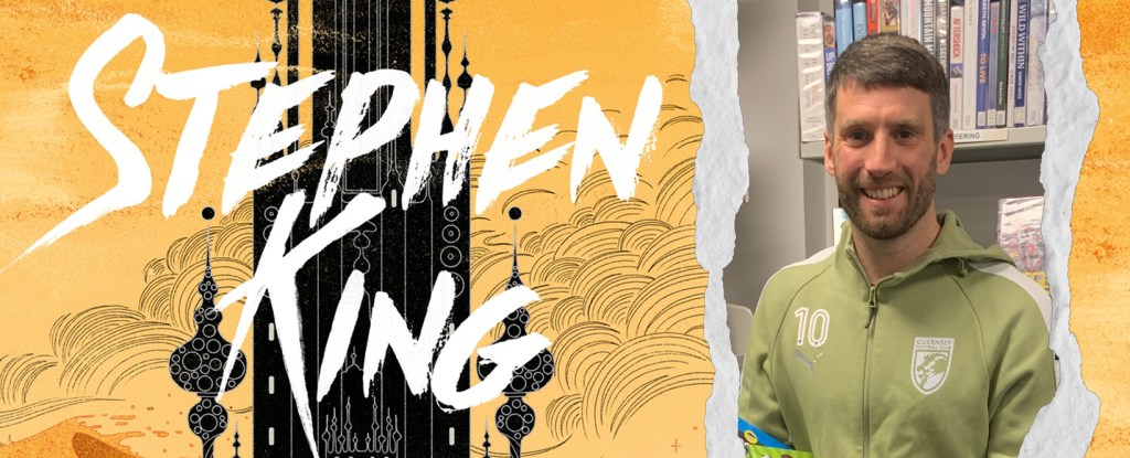 A split image shows an illustrated book cover–style design on the left, featuring bold orange and yellow tones with swirling cloud shapes and a tall black tower. Large white text reads “Stephen King.” On the right side of the composition, a man with a neat beard stands in a library aisle wearing a light‑green tracksuit top with the number 10 printed on it. Bookshelves filled with neatly arranged books line the background.