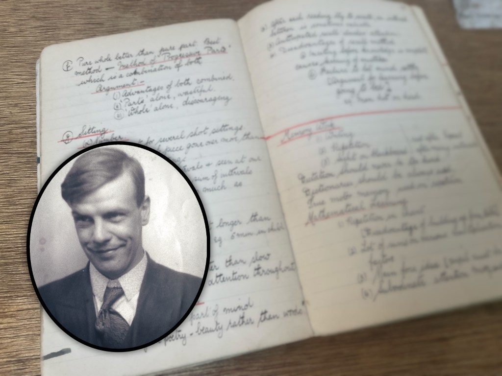 An old handwritten notebook lies open on a wooden surface, filled with neatly written notes in ink, some underlined in red. The pages show headings, numbered points, and annotations. In the lower-left foreground, there is an inset oval photograph showing a smartly-dressed man in a suit and tie. The photograph has a slightly faded, vintage appearance.