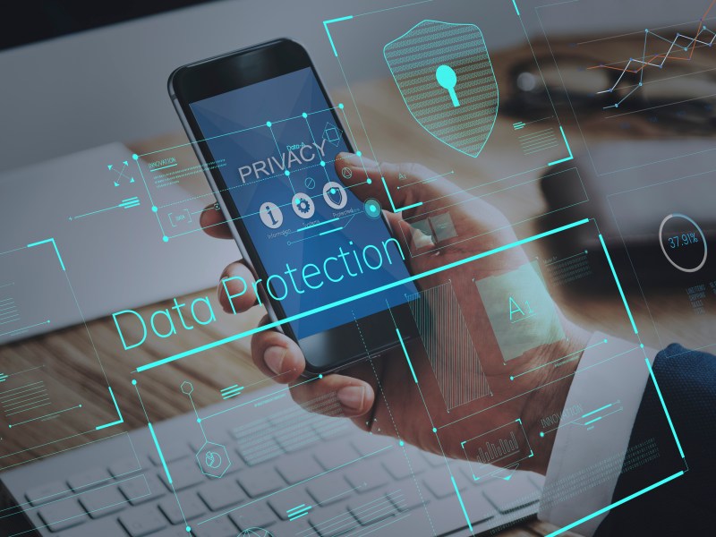 A mobile phone along with some abstract images representing data privacy and protection.