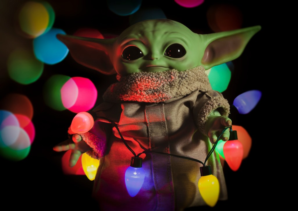 Baby Yoda wrapped in coloured Christmas lights.