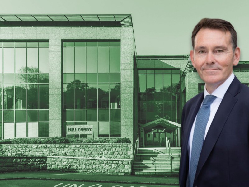 A man in a suit. He's in front of a building.