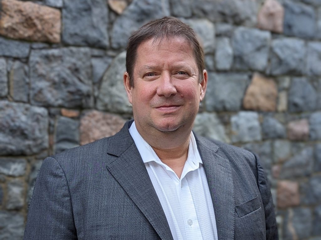 A man in a grey suit and white shirt.