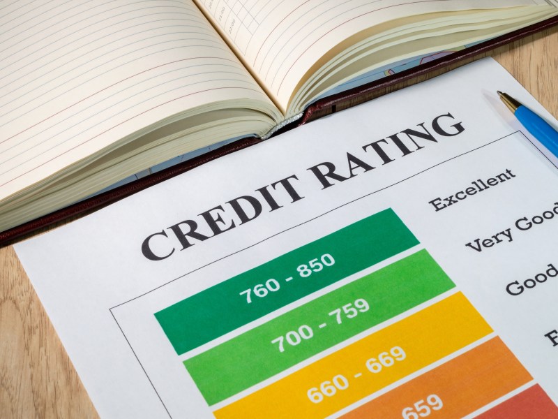 Credit rating of paper and pen on bright wooden office desk.