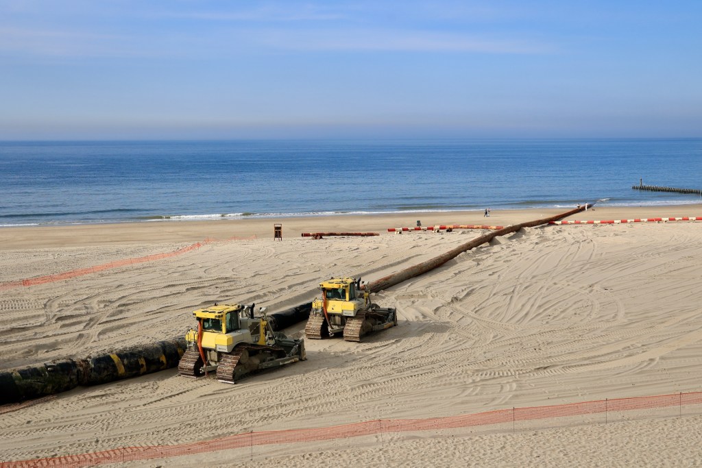 Domburg, Zeeland, The Netherlands - 23 March 2025: Submarine Cable. Repair work in Zeeland on a sandy beach, with a long pipeline extending towards the North sea. Underwater pipeline installation.