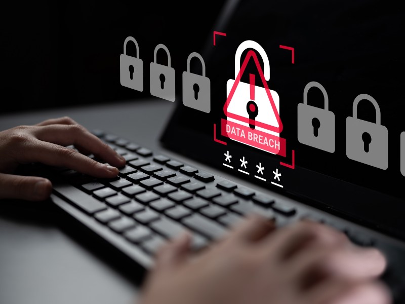 Data breach image - tech screen with keyboard and warning icons.