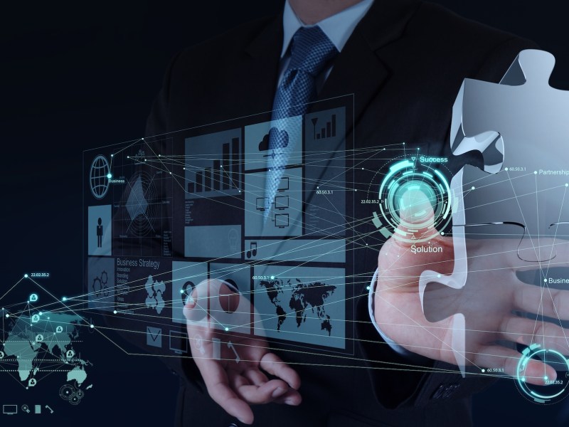businessman hand working with computer interface show puzzles as partnership concept