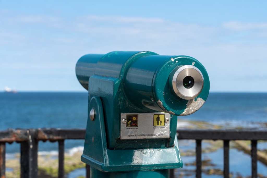 A tourist telescope or tower viewer on the sea front, reminiscent of visits to the seaside.