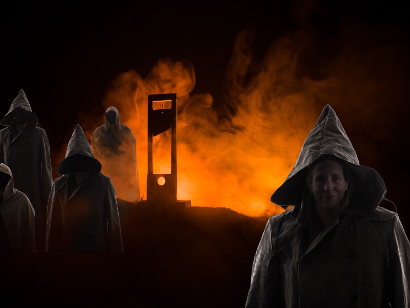 several hooded figures in front of a guillotine