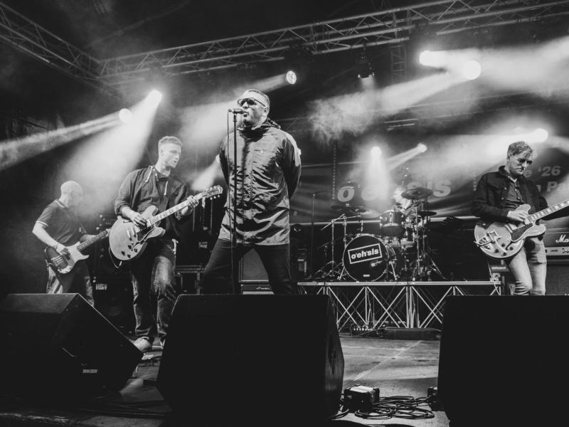 A black and white photo of a band performing on stage