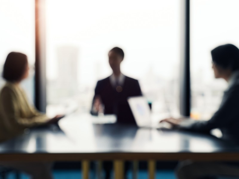 Blurred image of a group of business people having a meeting in an office
